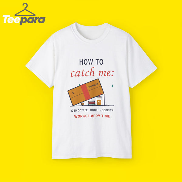 White unisex t-shirt with a cardboard box trap over iced coffee, books and a cookie and the text How To Catch Me