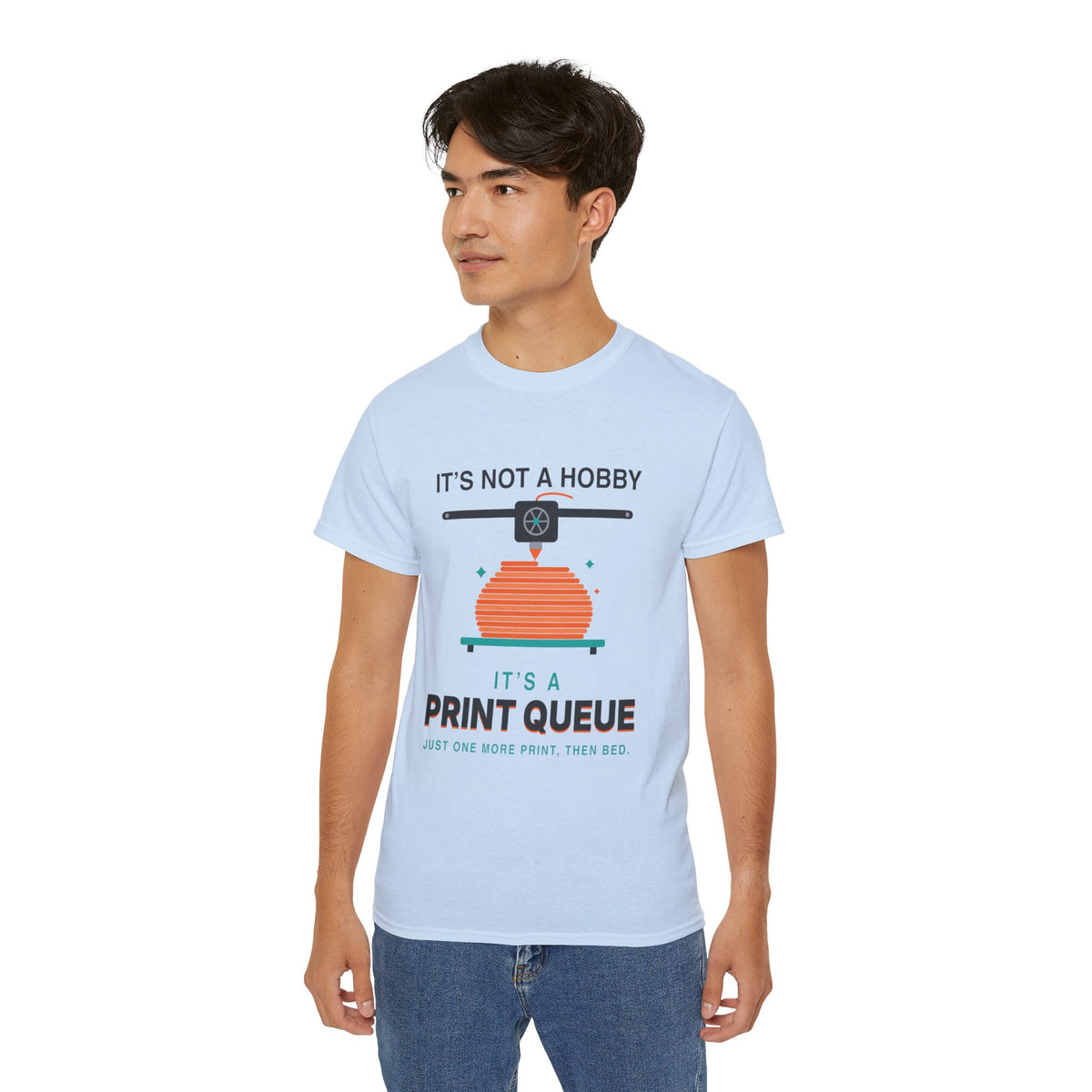 It's a Print Queue 3D printing graphic t-shirt by TeePara, folded and worn by a model