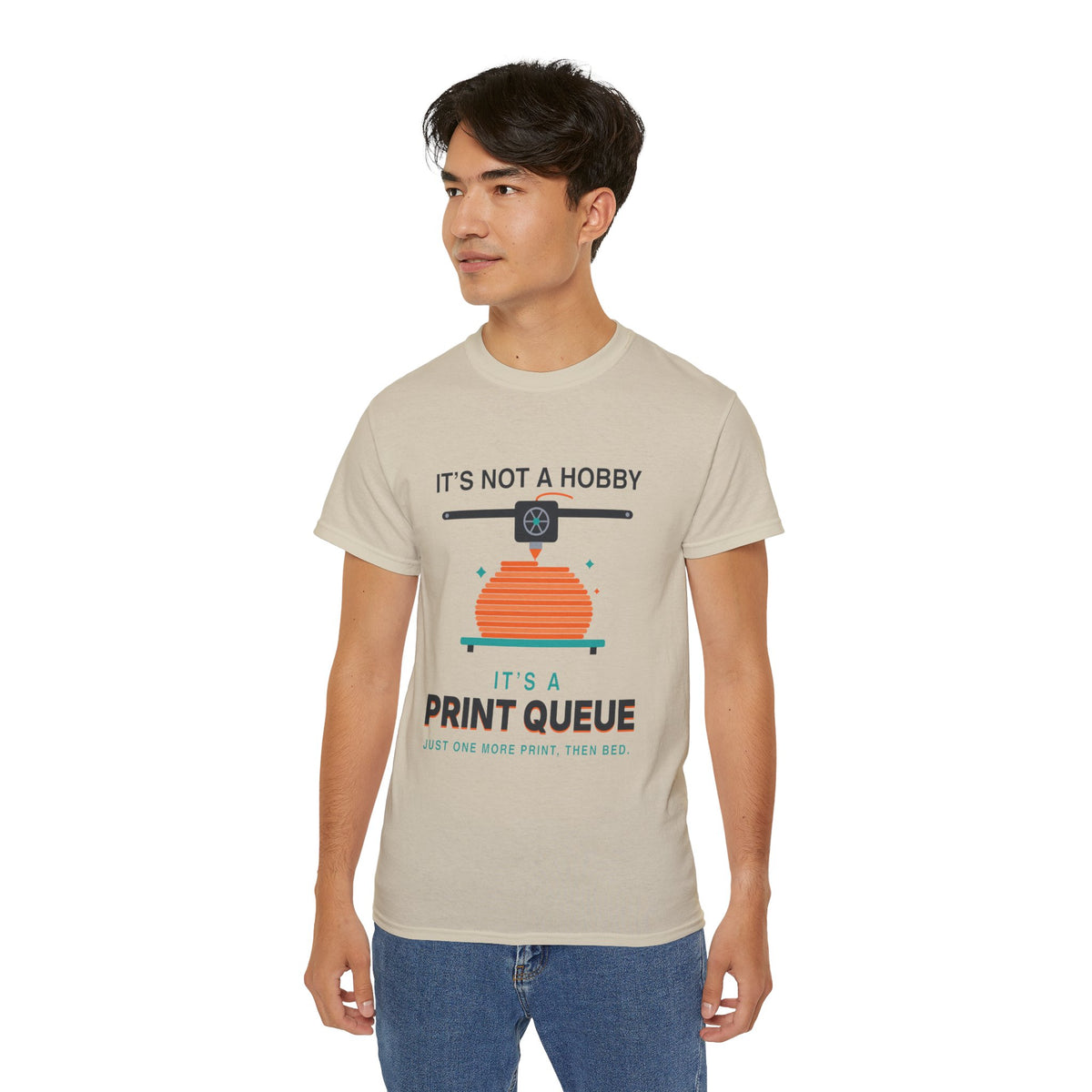 It's a Print Queue 3D printing graphic t-shirt by TeePara, folded and worn by a model