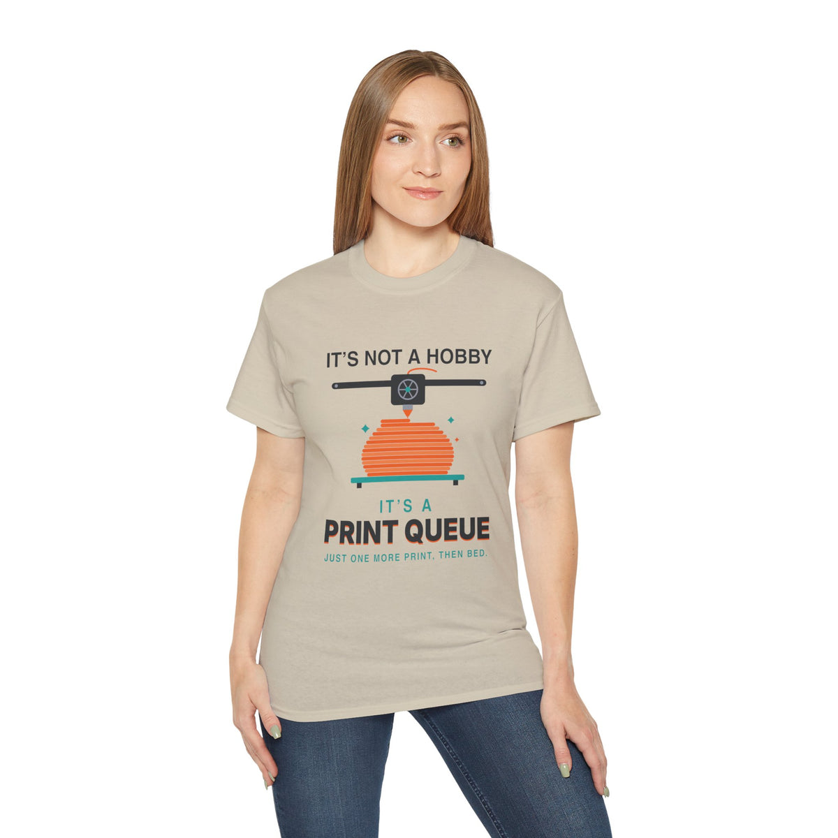It's a Print Queue 3D printing graphic t-shirt by TeePara, folded and worn by a model