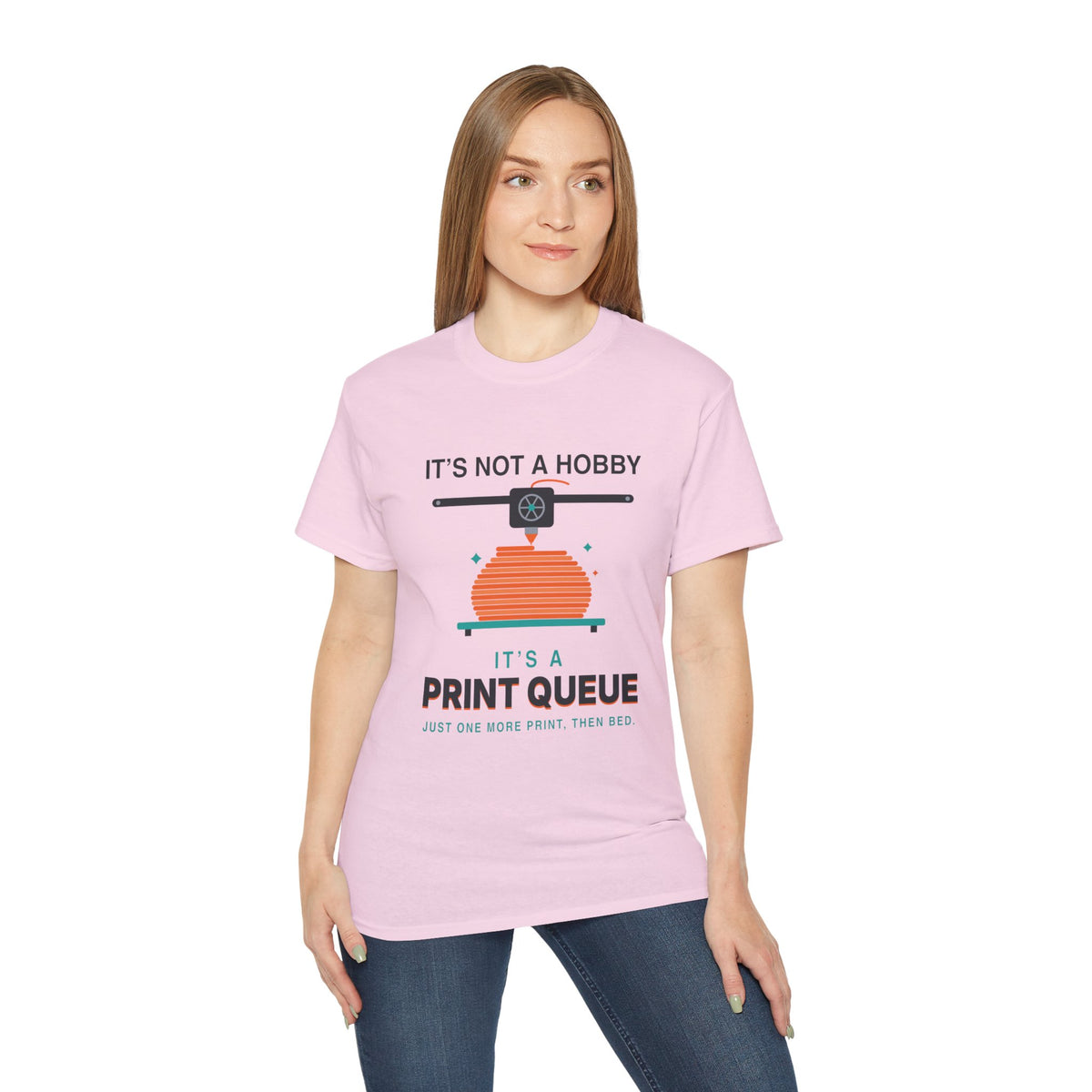 It's a Print Queue 3D printing graphic t-shirt by TeePara, folded and worn by a model