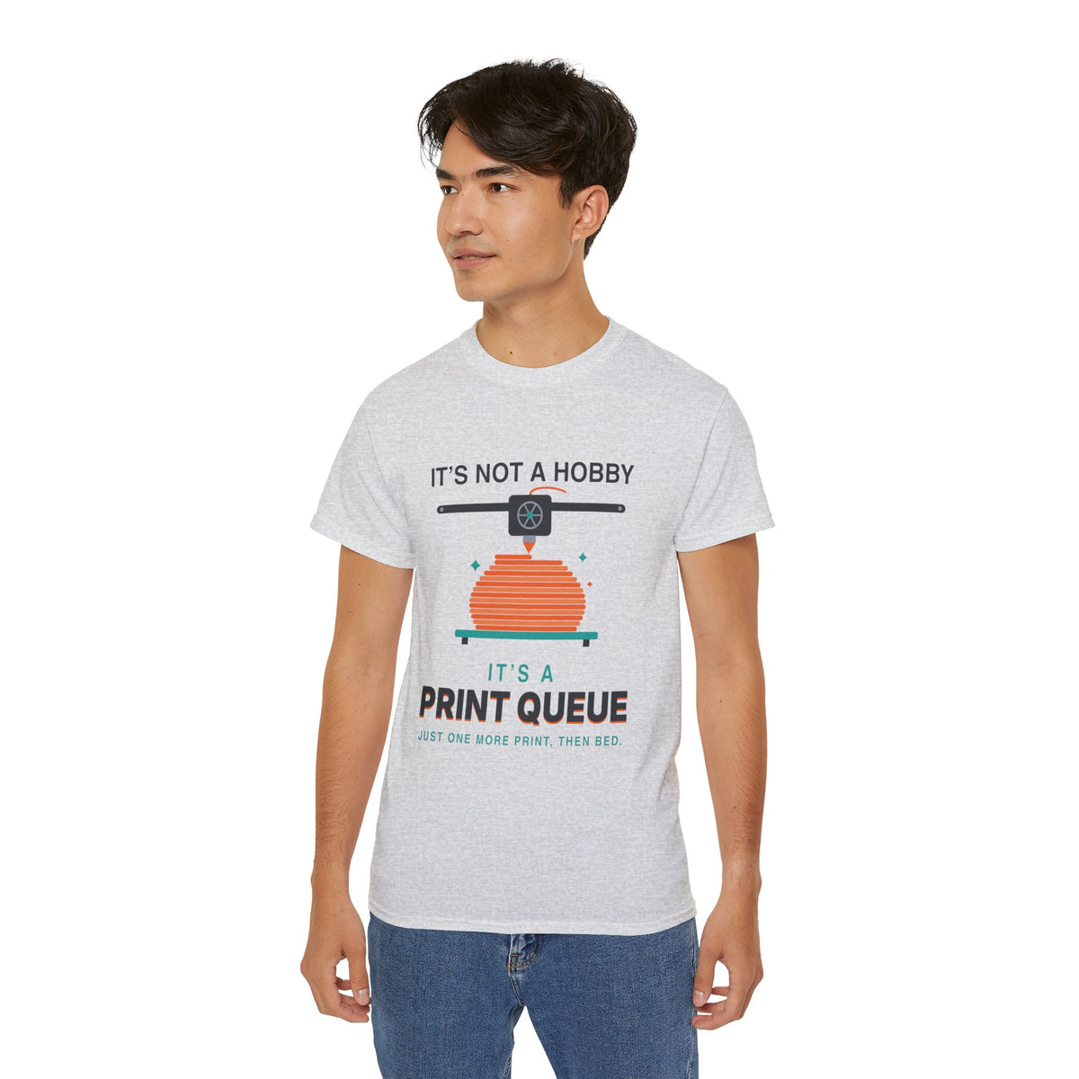 It's a Print Queue 3D printing graphic t-shirt by TeePara, folded and worn by a model